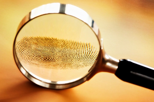 A magnifying glass investigating a fingerprint