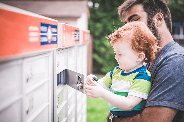 Father holding his son in front of a mailbox