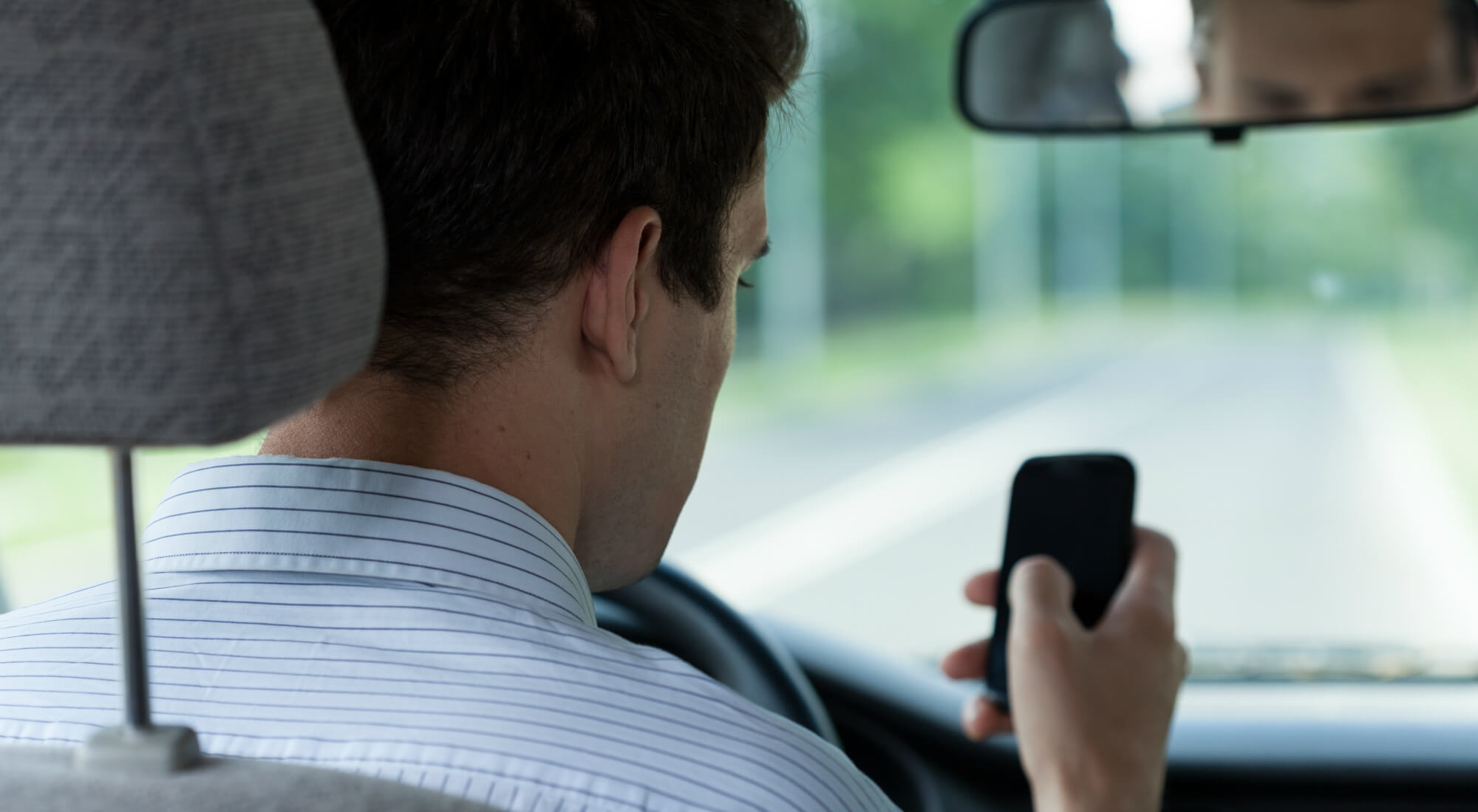 Distracted driver looking at cellphone while driving